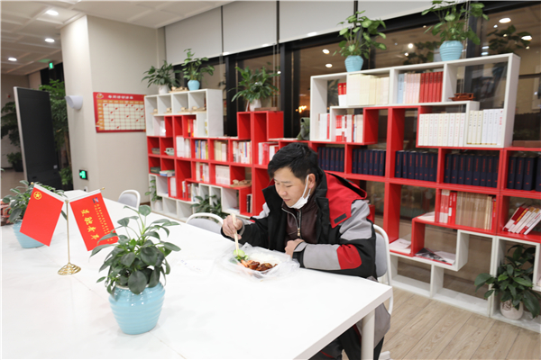 意外滞留在园区内的快递小哥收到了青年志愿者送来的一份热腾腾晚餐，让这个冬雪夜更暖心.jpg